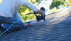 Rainwater flows through clean gutters and downspouts away from a residential roof during a storm.